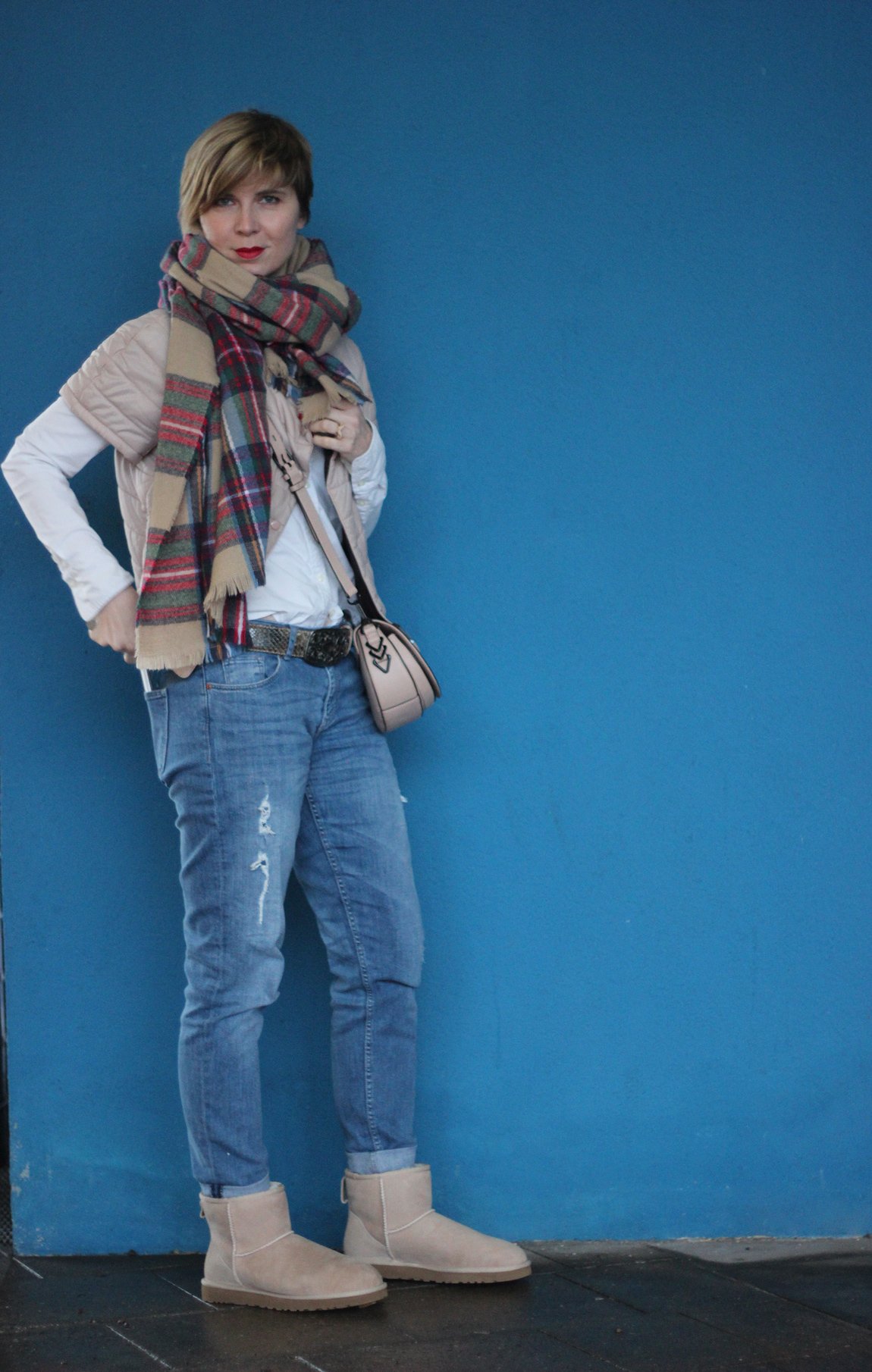 Outfit komplett vor blaure Wand- Boyfriend Jeans, Windsor Jacke, weiße Bluse und UGGs hellbeige