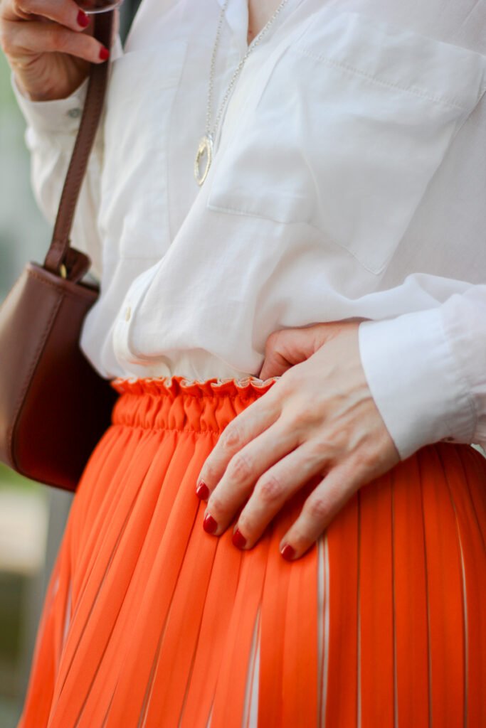 conny-doll-lifestyle: zweifarbiger Plisseerock, orange, weiße Bluse, Sommerlook